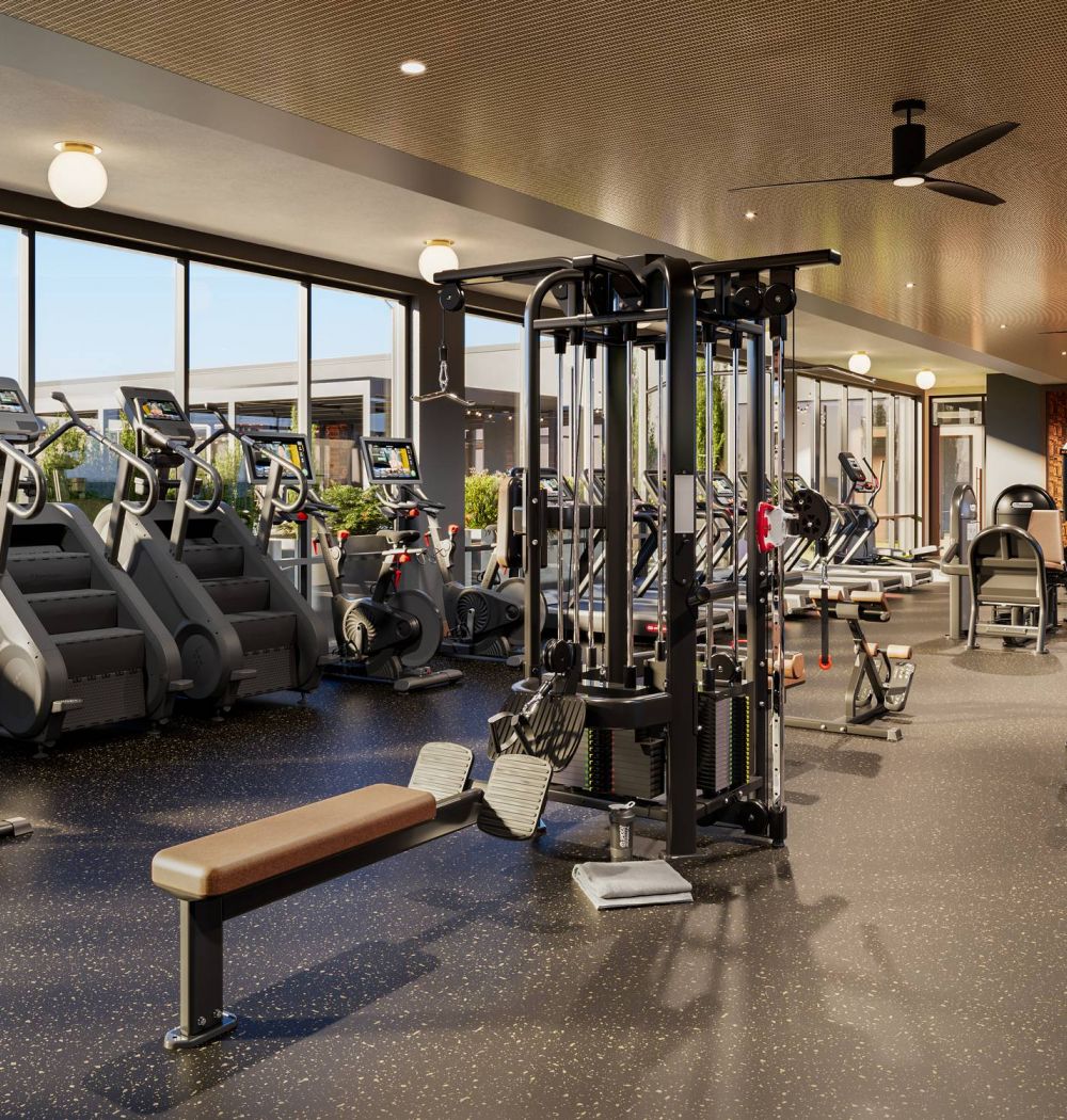 LOCAL On Delmar apartments With turf training equipment including a TireFlip 180 and agility ladders for dynamic, full-body workouts. Spacious gym with cardio machines, weight benches, and strength equipment, with large windows and natural light.
