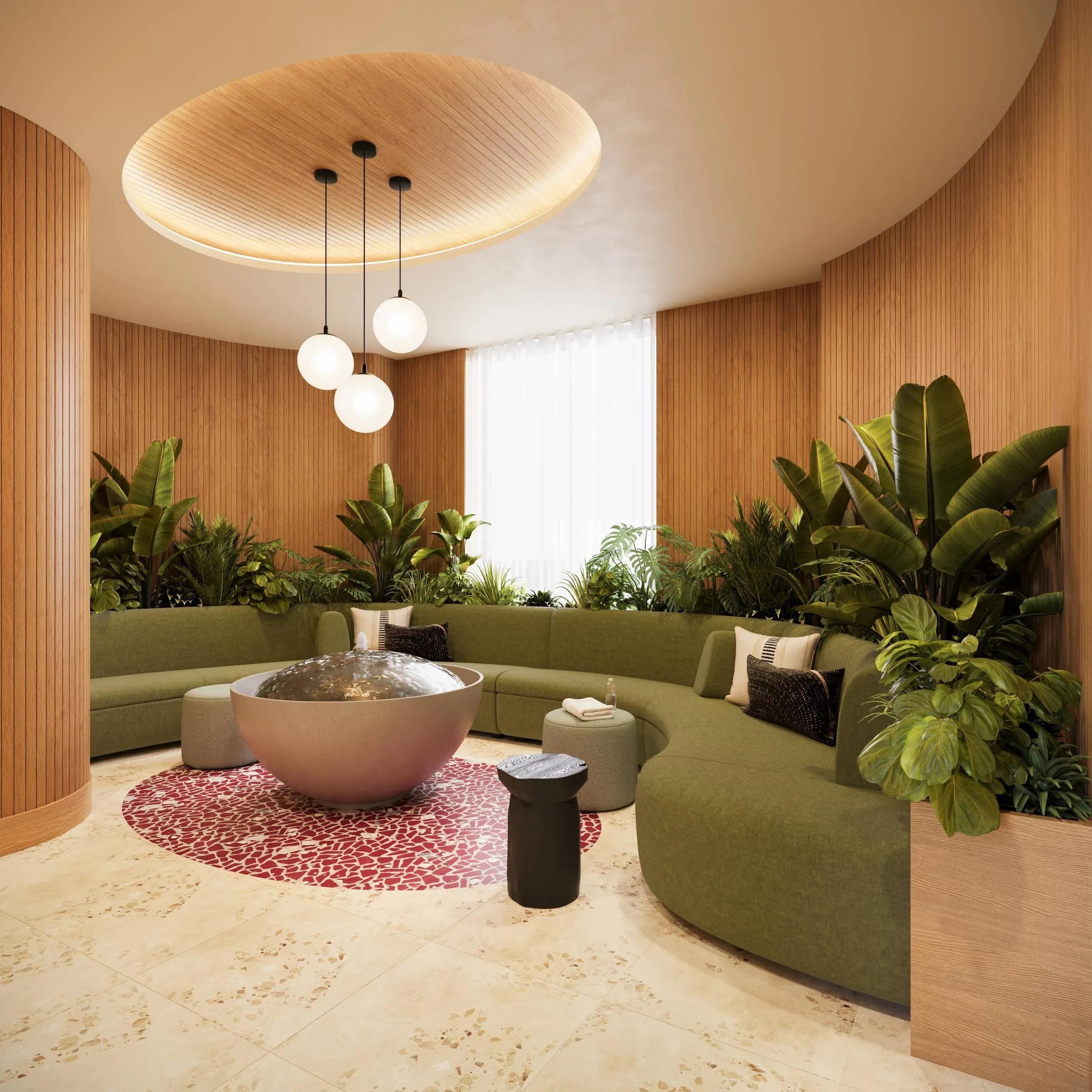 Modern lounge with green curved sofas, lush plants, round rug, and a central bowl under globe pendant lights.